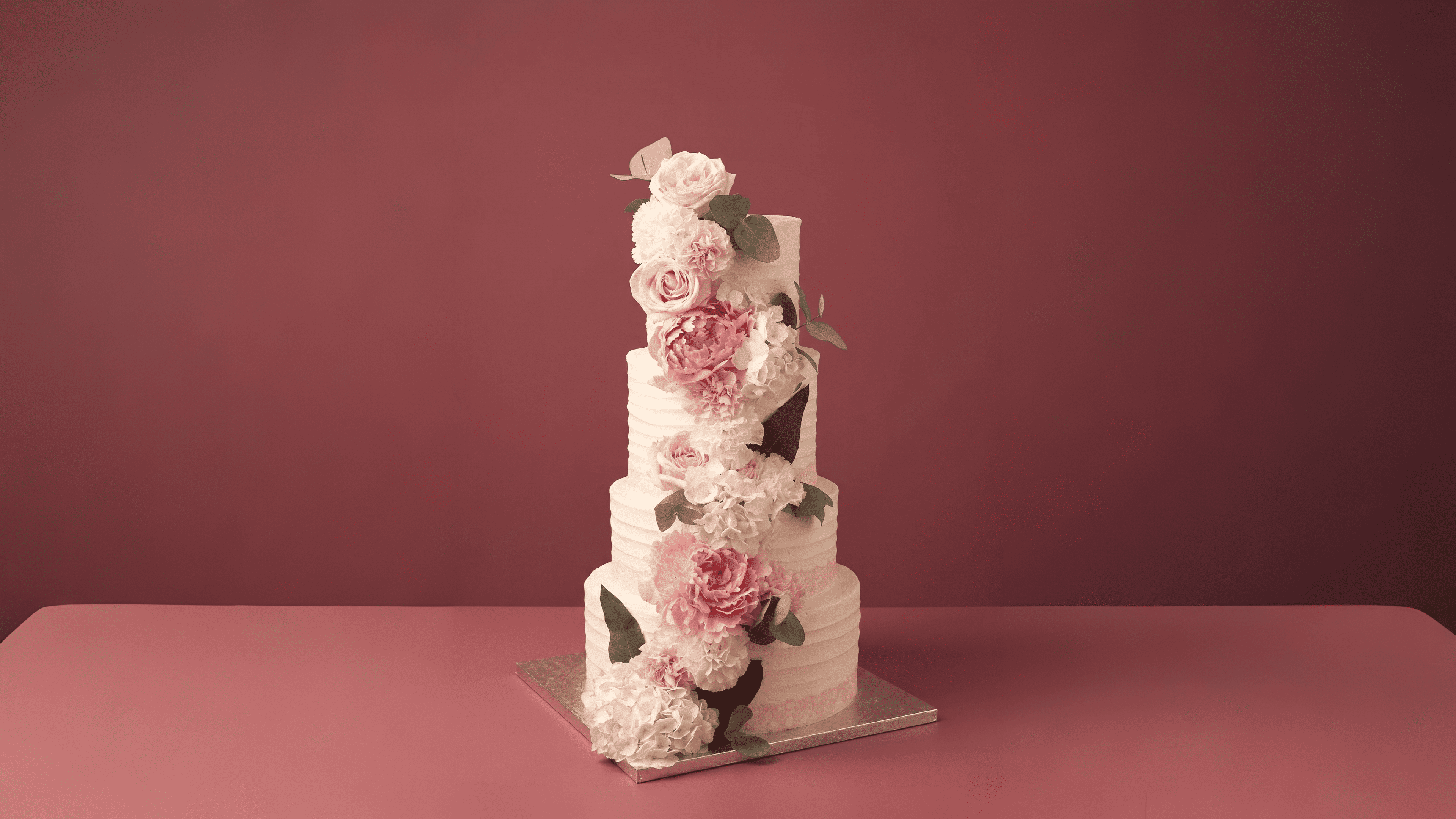 Tarta de boda de varios pisos decorada con flores naturales